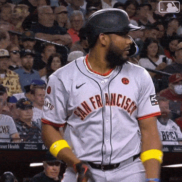 a baseball player wearing a san francisco jersey stands in front of the crowd