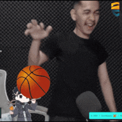 a man in a black shirt is holding a basketball in front of a microphone