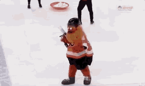 a person in a hockey uniform is holding a hockey stick in their hand while standing on the ice .