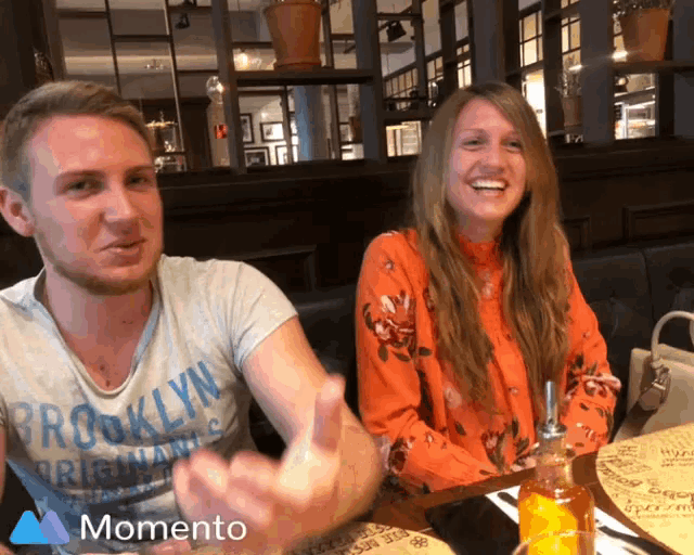 a man wearing a brooklyn shirt talks to a woman