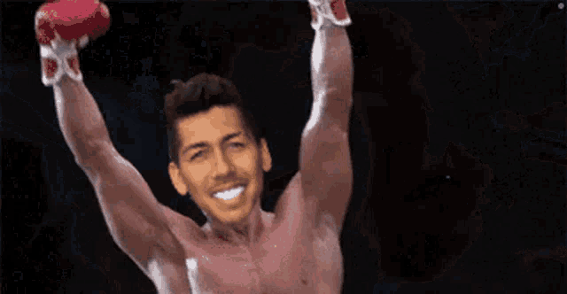 a shirtless boxer with his arms in the air .