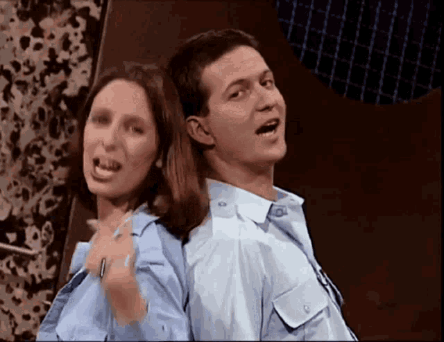 a man and a woman are back to back and singing into microphones