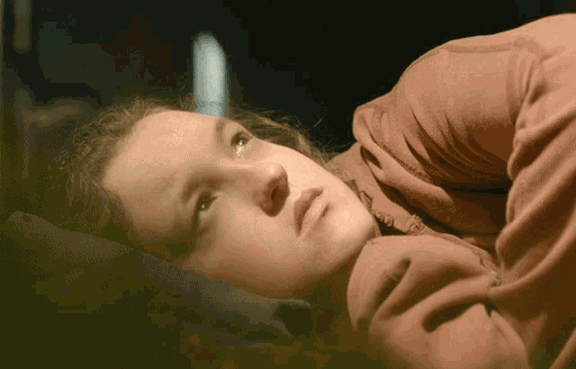 a woman in a red shirt is laying down