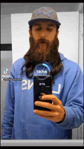 a man with a long beard is taking a picture of himself with a tiktok icon