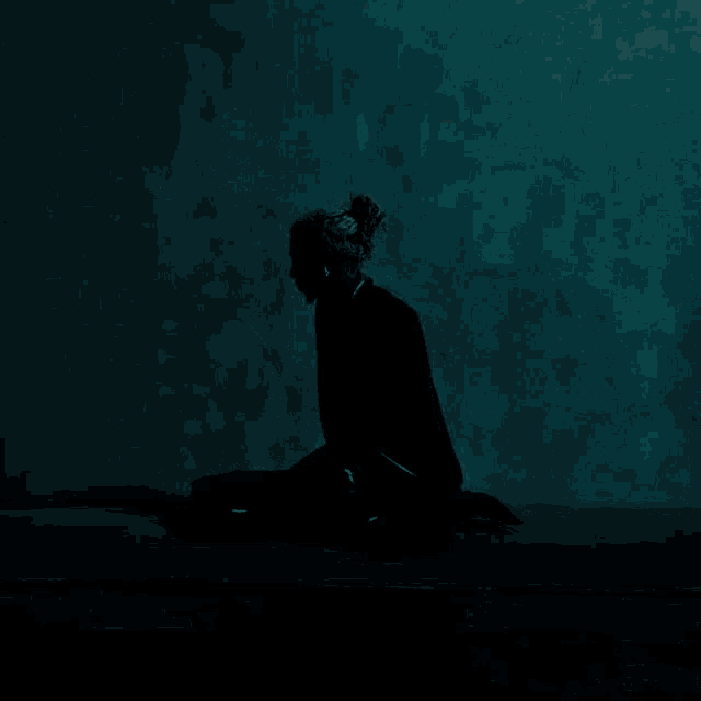 a silhouette of a person in a dark room with a blue background