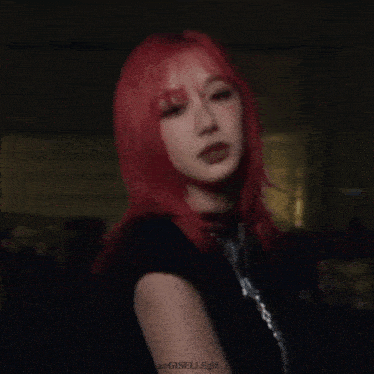 a woman with red hair and a black shirt is wearing a necklace .