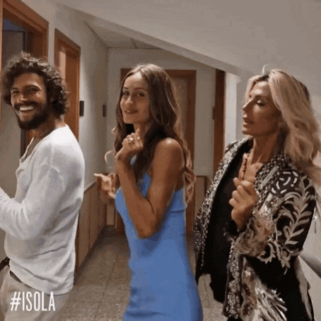 a man and two women are dancing in a hallway with #isola written on the bottom right