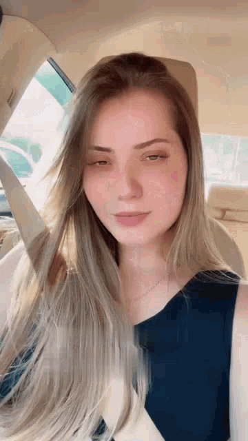 a young woman is sitting in the back seat of a car with her eyes closed .