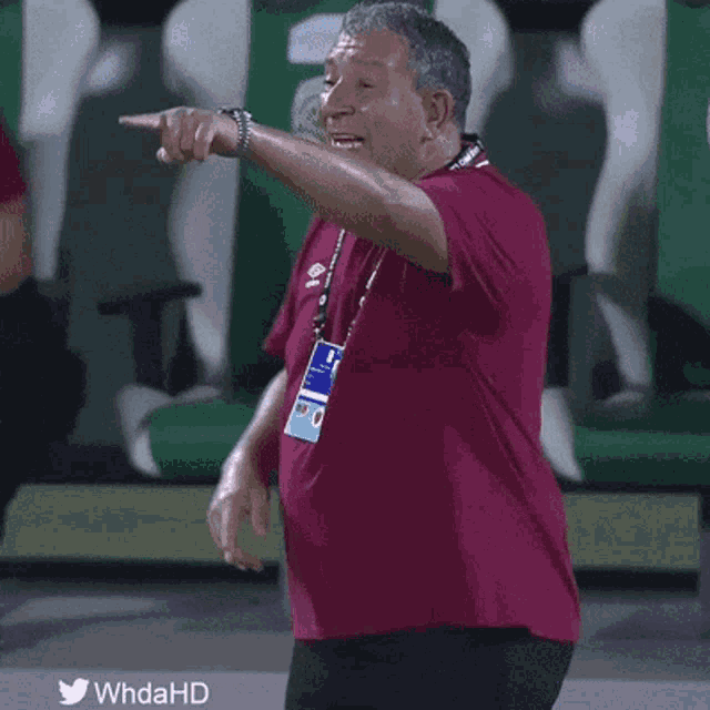 a man in a red shirt is pointing at something with the twitter hashtag whdahd at the bottom