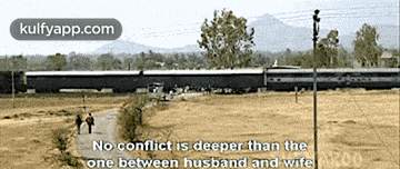 a couple walking down a path next to a train that says kulfyapp.com