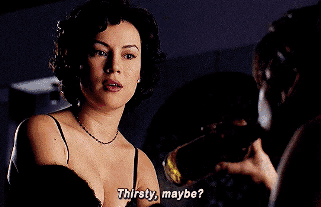 a woman in a bra says thirsty maybe while holding a bottle