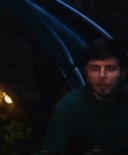 a man in a green shirt is being served a piece of food