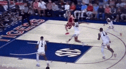 a group of basketball players are playing a game on a court with a dollar sign on the floor .