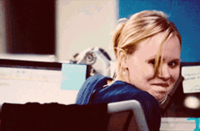 a woman with blonde hair is sitting in front of a computer screen