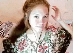 a woman with red hair is wearing a floral shirt and a necklace .