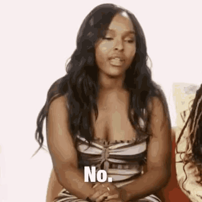 a woman in a striped dress is sitting on a couch and saying `` no '' .