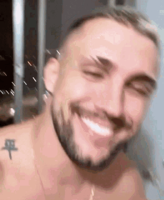 a shirtless man with a beard is smiling .