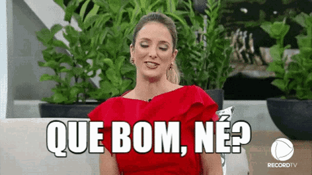 a woman in a red dress is sitting on a couch and says que bom , ne ?