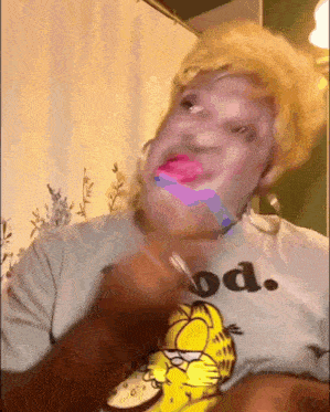 a woman is wearing a garfield t-shirt and making a funny face