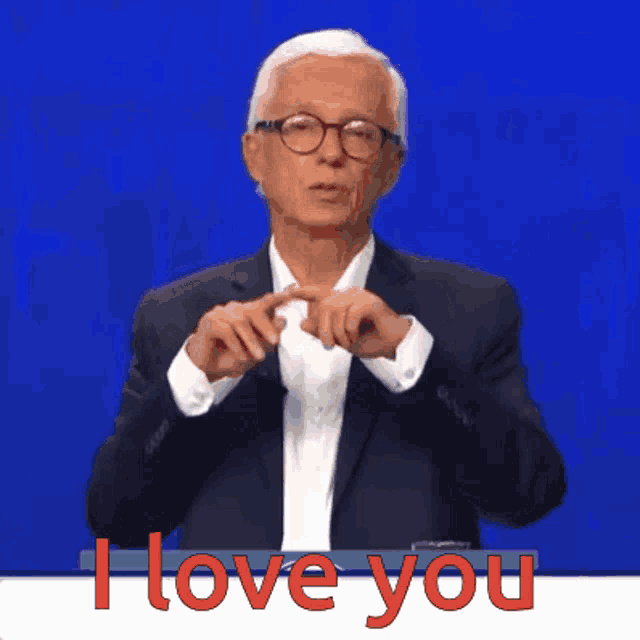 a man in a suit and glasses says " i love you " in red letters