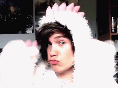 a boy wearing a white furry hat with pink spikes