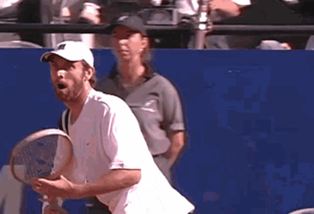 a man in a white shirt is holding a tennis racquet in his hands
