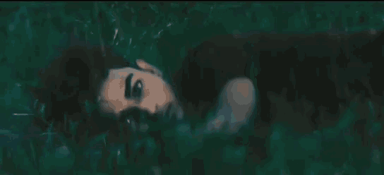 a man is laying on his back in the grass in the dark .