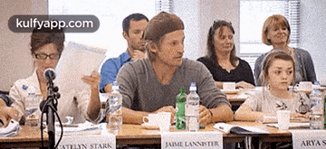 a group of people sitting at a table with a sign that says jaime lannister on it