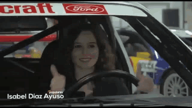 isabel diaz ayuso is giving a thumbs up in a car
