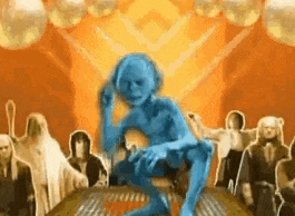 a group of people are standing around a table with a blue figure sitting on it .