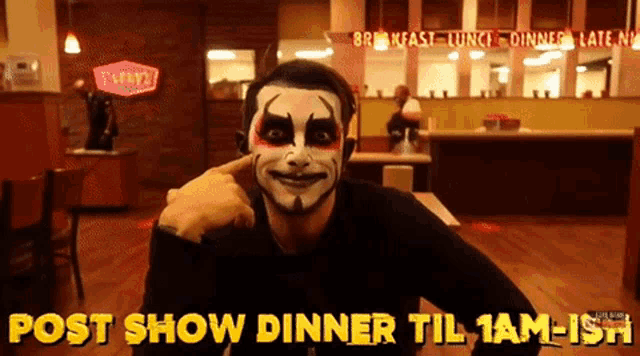 a man with face paint is sitting at a table with the words post show dinner til 1 am-ish