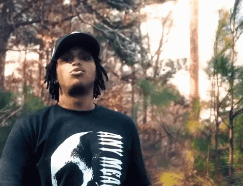 a young man wearing a black shirt that says any mean