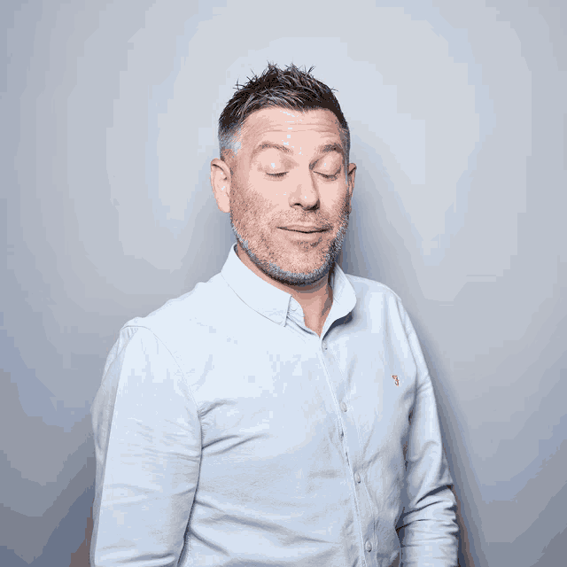 a man with his eyes closed is wearing a light blue shirt with the letter j on it