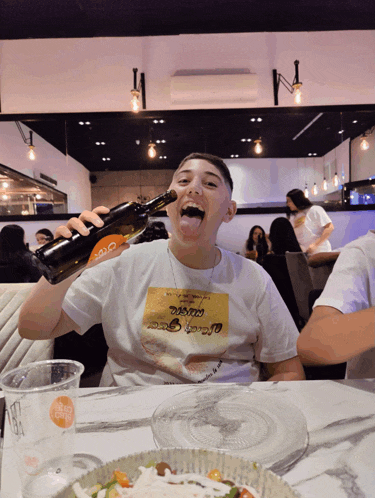 a man wearing a t-shirt that says ' black magic ' on it holds a bottle of wine