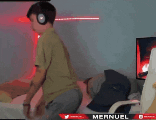 a person wearing headphones is standing in front of a screen that says mernuel