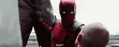 a man in a deadpool costume is talking to another man in a superhero costume .