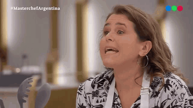 a woman is making a funny face in front of a screen that says masterchefargentina