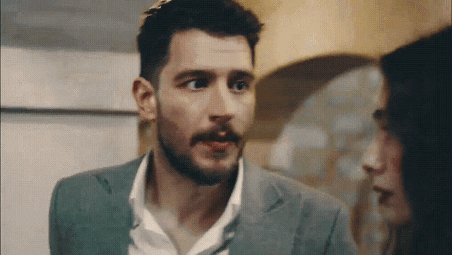 a man with a beard and mustache looks at a woman