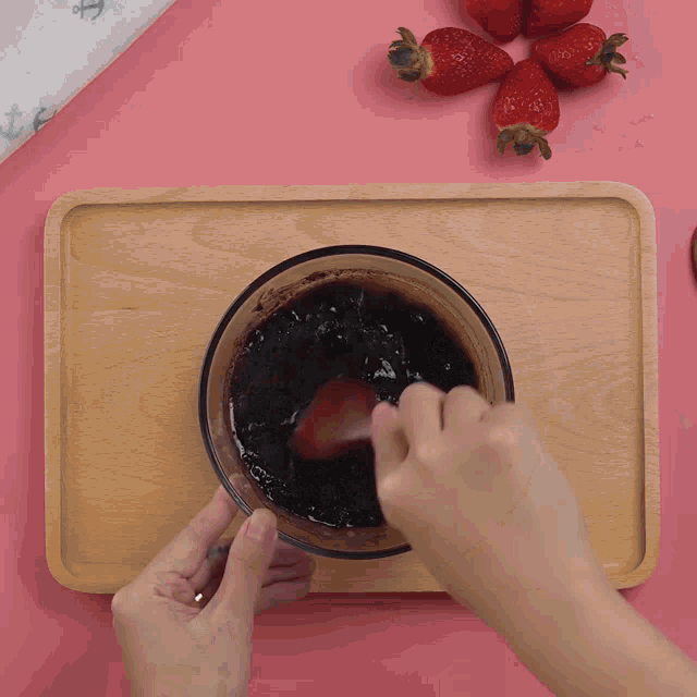 a person is pouring something into a pan with a spoon