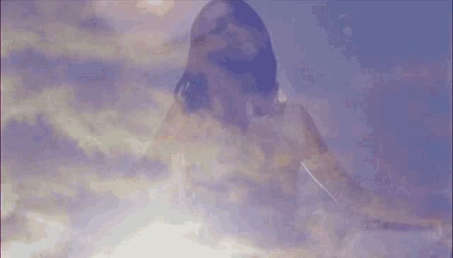 a double exposure of a woman in the clouds