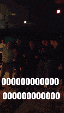 a group of people are dancing in a dark room with a blue light behind them that says 000000 on it
