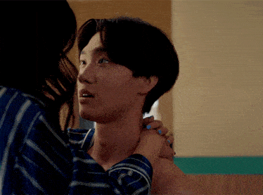 a woman with blue nails holds a man 's neck
