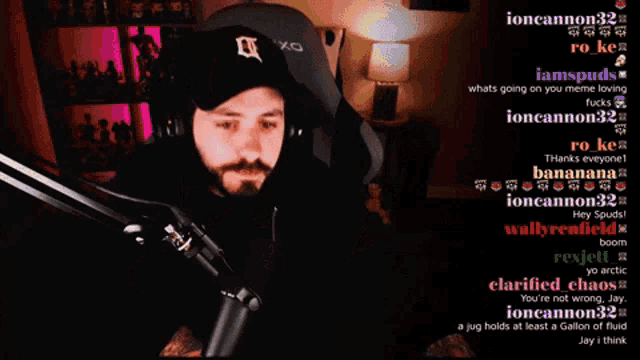 a man holding a gun in front of a microphone with a bunch of messages on the screen including one from sparkplugsquire