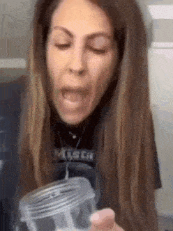 a woman is making a funny face while holding a jar .