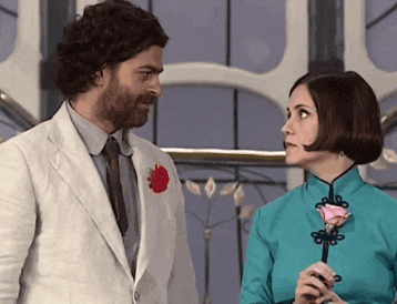 a man and a woman are looking at each other and the woman is holding a rose
