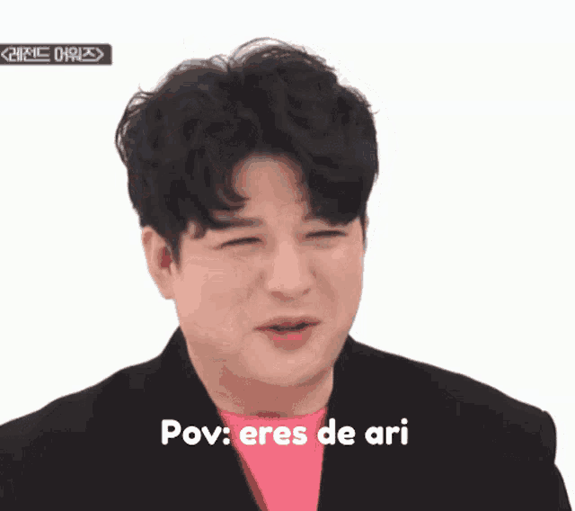 a man wearing a pink shirt and a black jacket with the words pov eres de ari below him