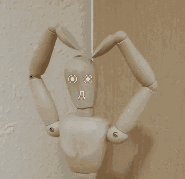 a wooden mannequin with a face that says " d " on it
