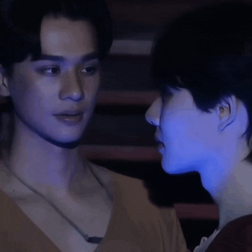 a man and a woman are looking at each other in the dark .