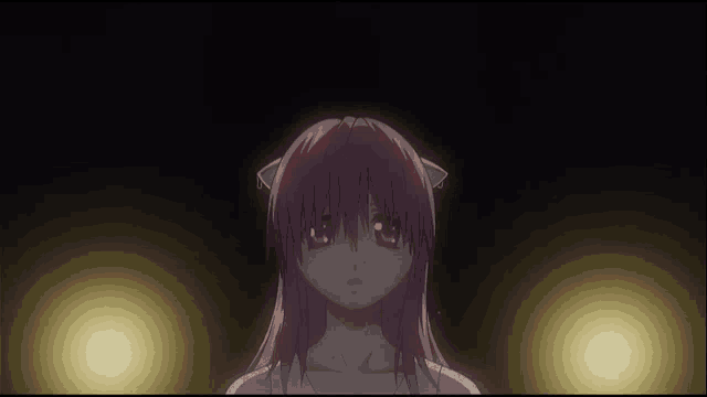 a girl with pink hair is looking at the camera in the dark