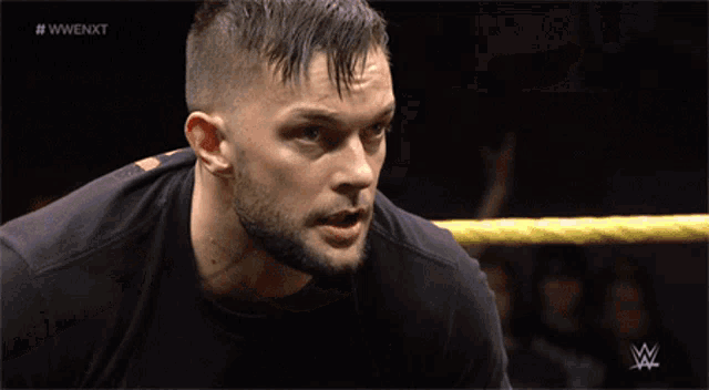 a man in a wrestling ring with the words #wwenxt on the bottom right
